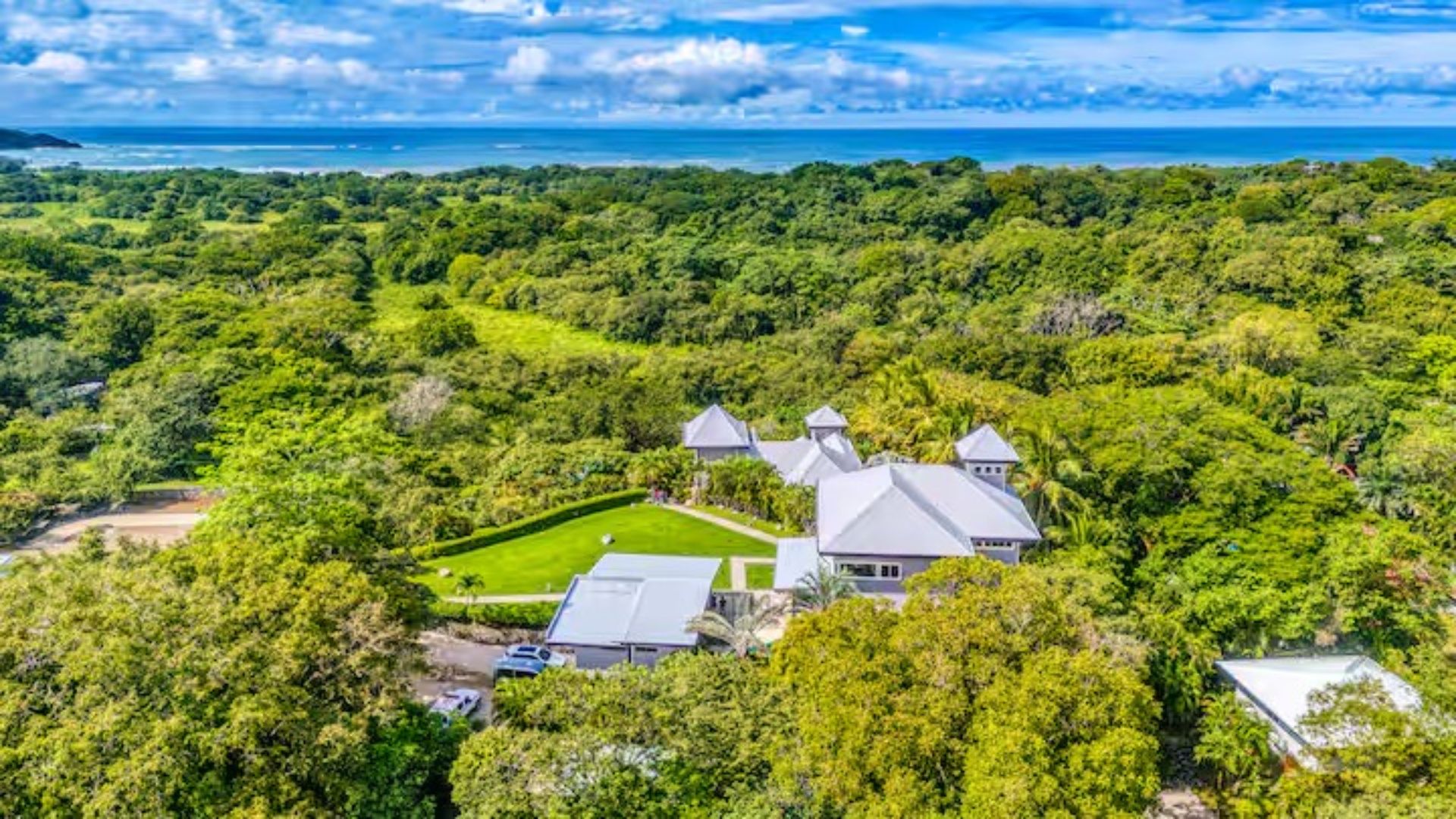 Aerial view of the Costa Rica retreat villa surrounded by lush green jungle with the Pacific Ocean in the background