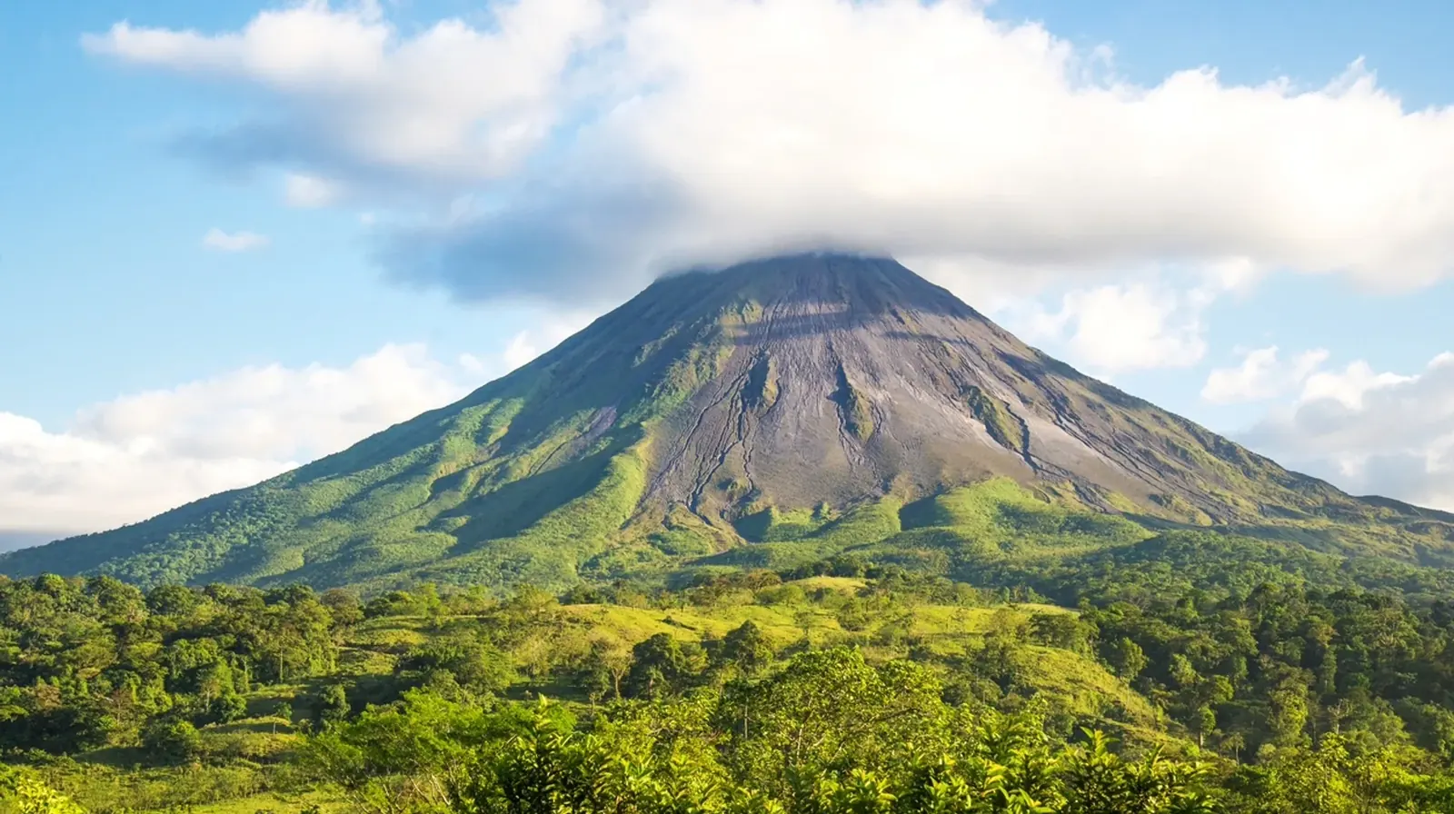 Arenal Volcano rising above tropical green hills in Costa Rica
