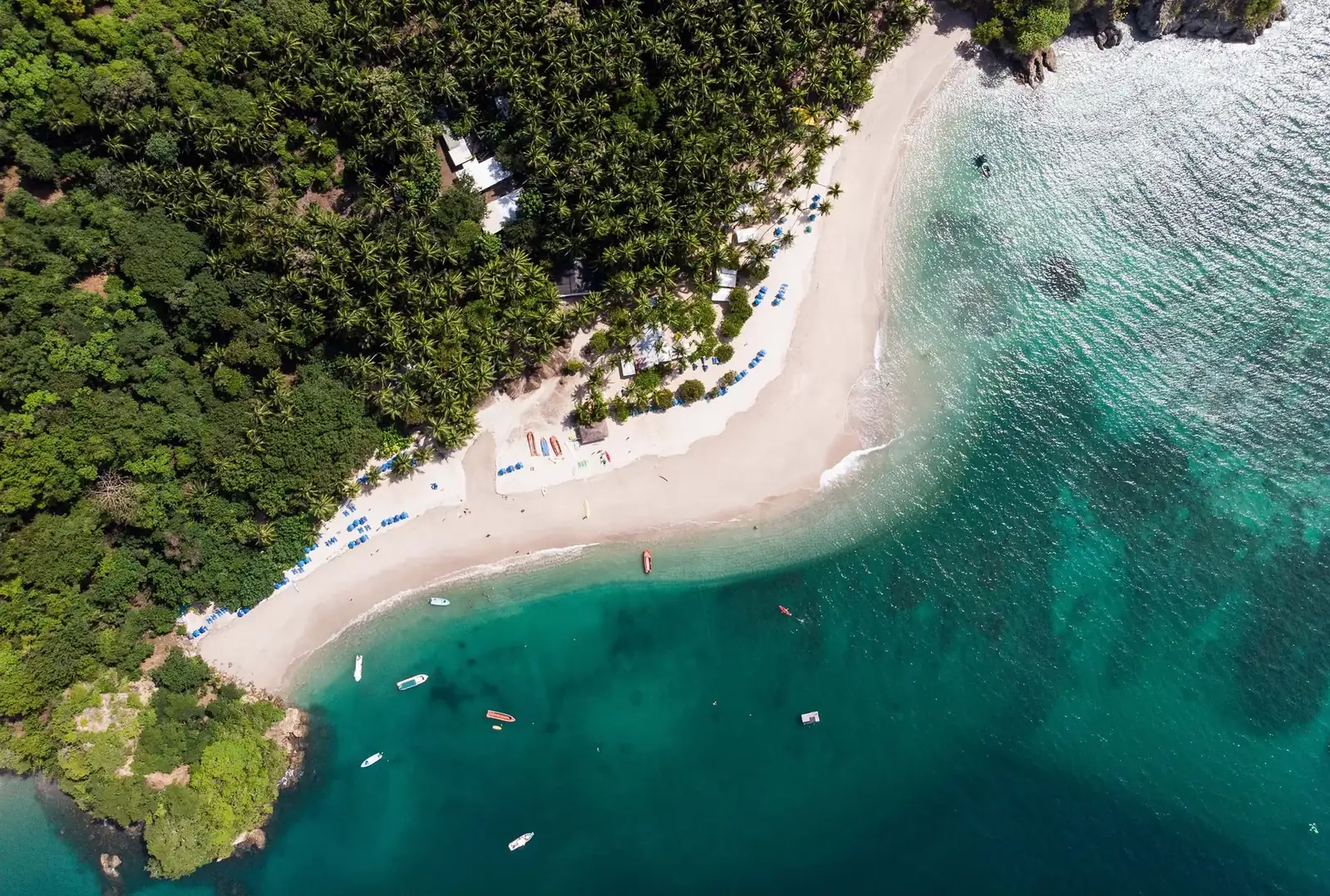 Aerial view of a forest-lined beach and turquoise sea in Costa Rica