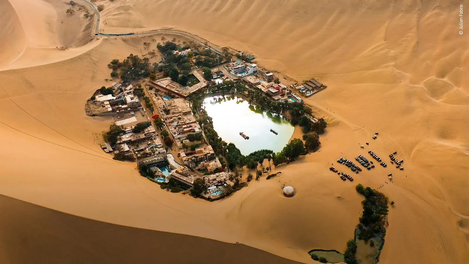 Huacachina oasis surrounded by golden desert dunes in Peru